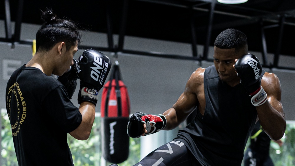 Two martial artists sparring inside a gym